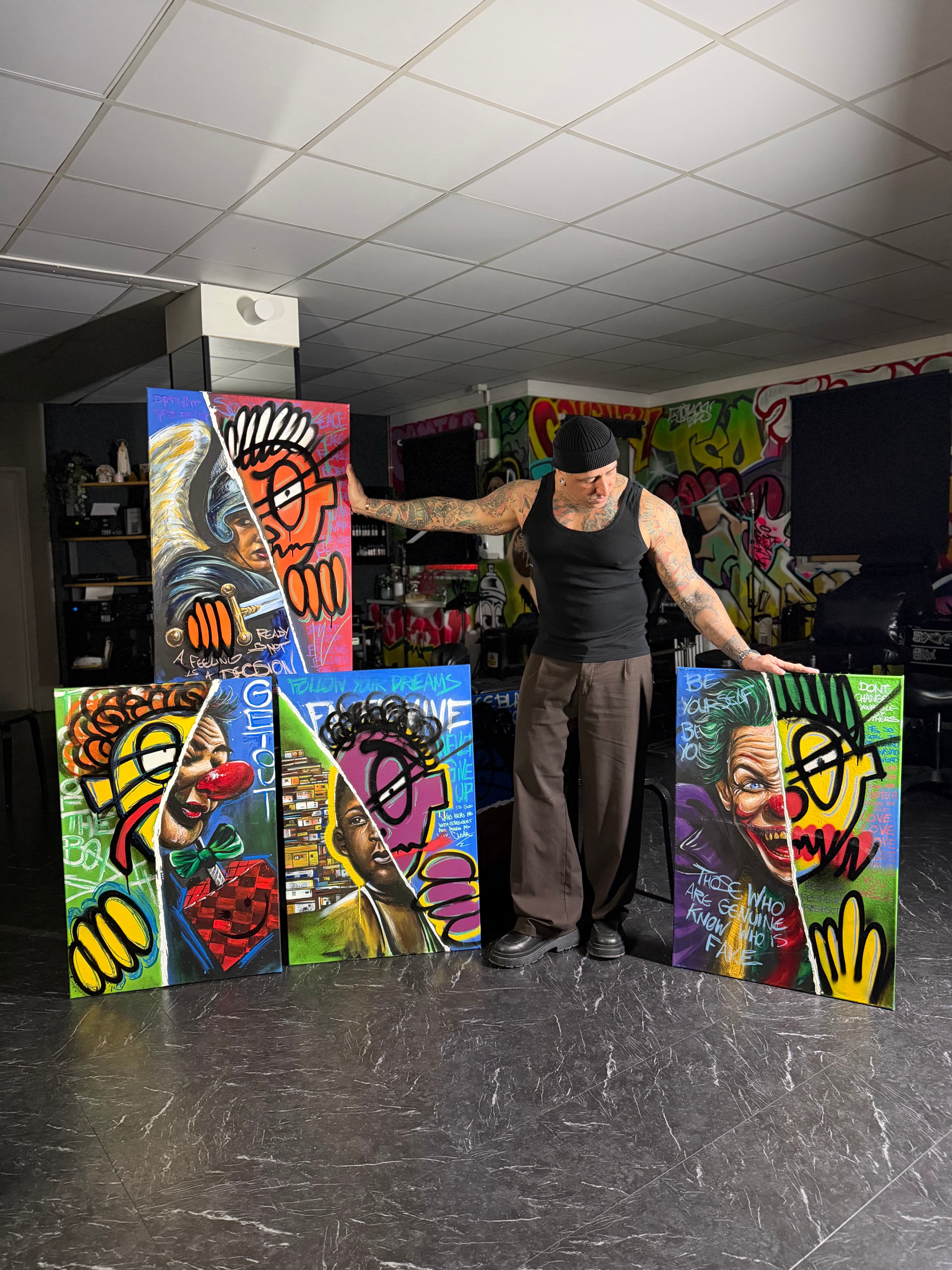 André Fila standing with paintings from the Chaos and Dignity series